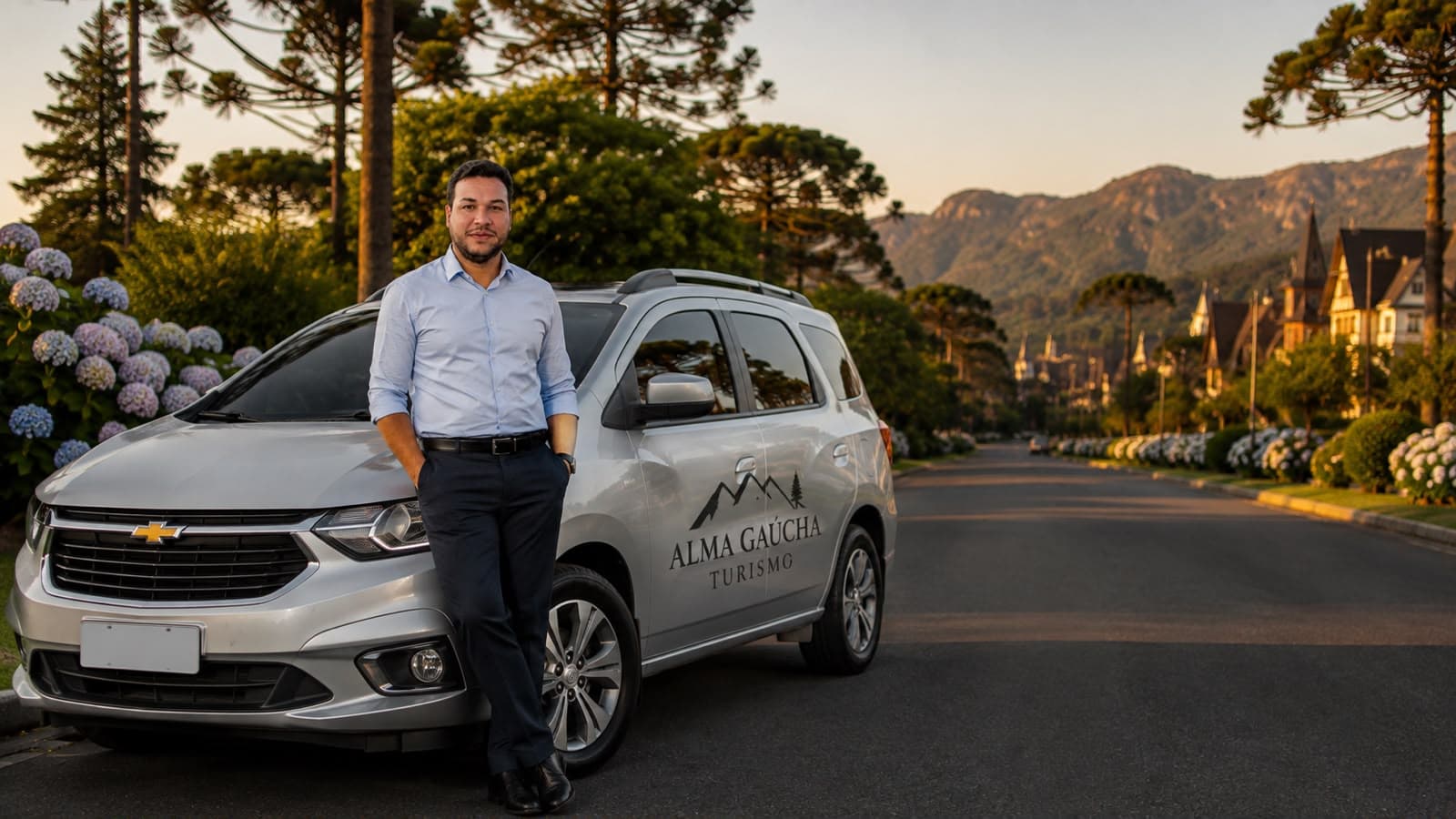 Eriel Fernando ao lado do veículo da Alma Gaúcha Turismo, em uma rua arborizada de Gramado